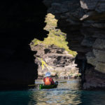 Kayaking through a cove in Scotland