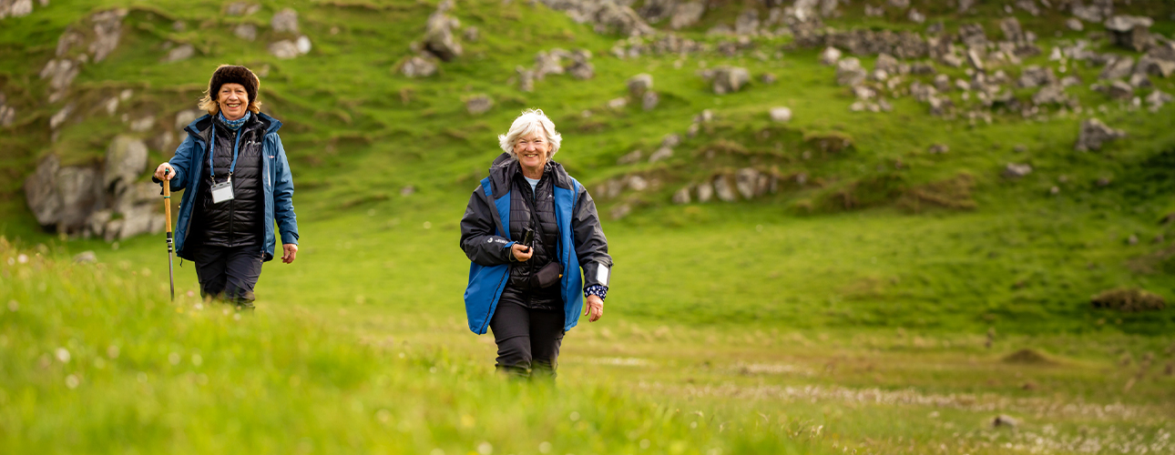 Two guests walking on a green Scottish island