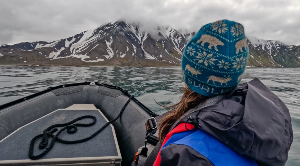 Woman in zodiac in front of dramatic mountains, Akseloya, Svalbard, David Stock @DivergentTravelers